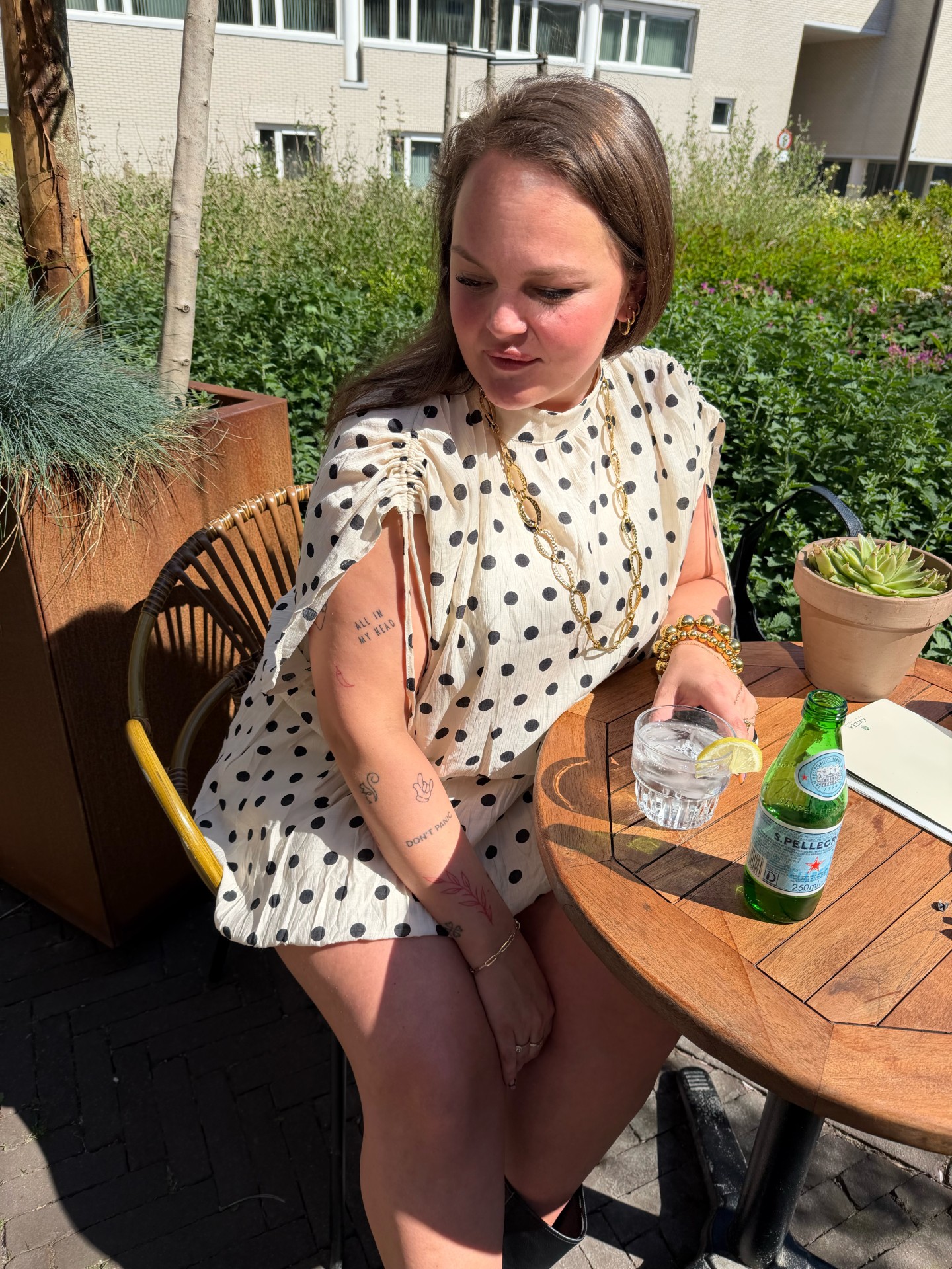 Frenky's Fashion: polkadot jurk met gouden sieraden op terras